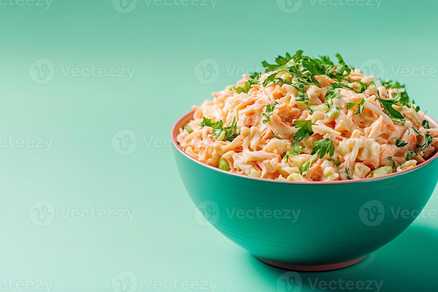 A bowl of carrot salad with parsley on a green background photo