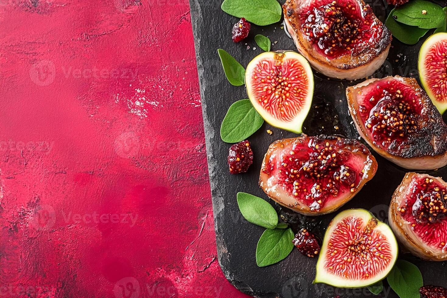 Grilled figs with balsamic vinegar and honey on a black slate photo