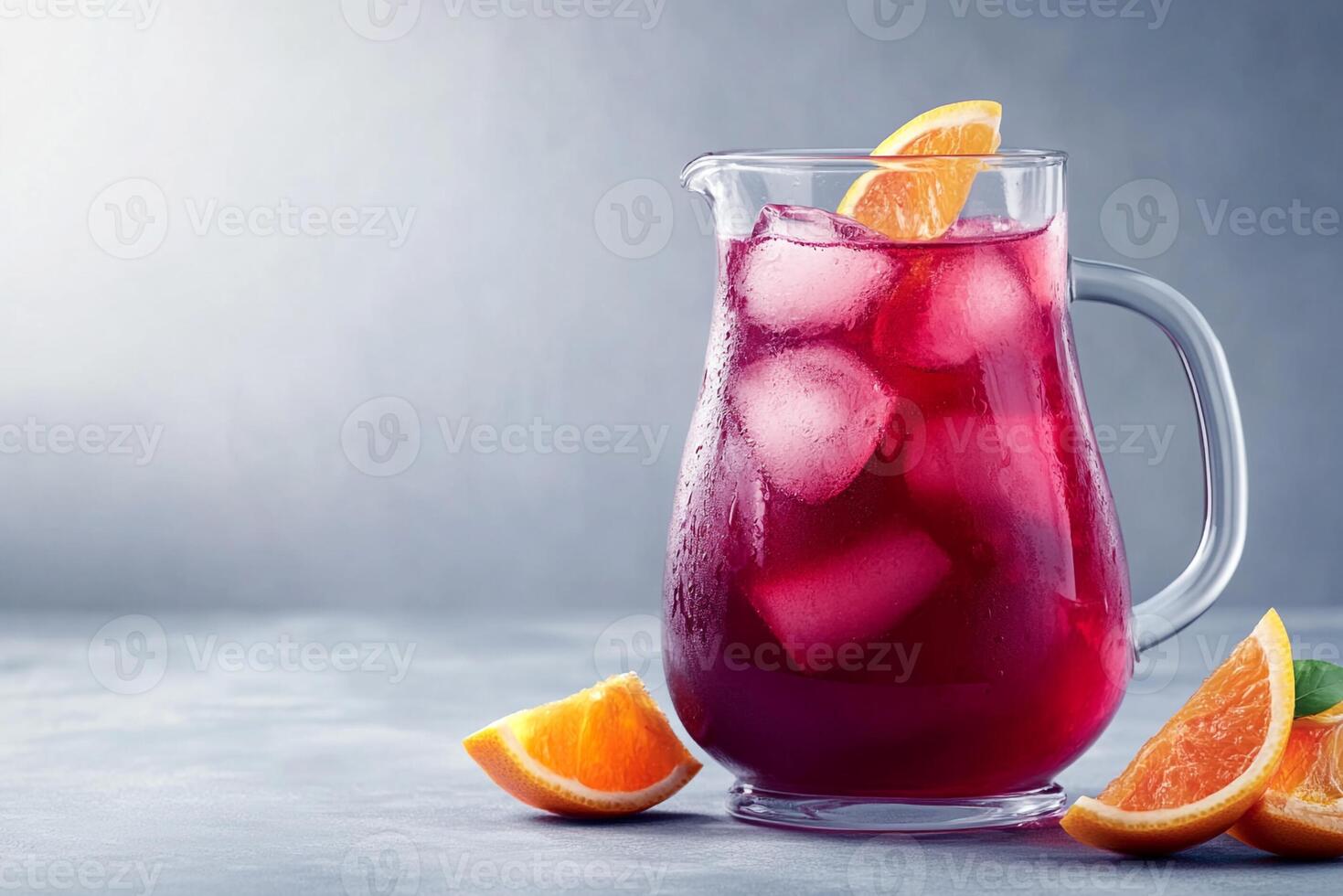 A pitcher of red sangria with oranges and ice photo