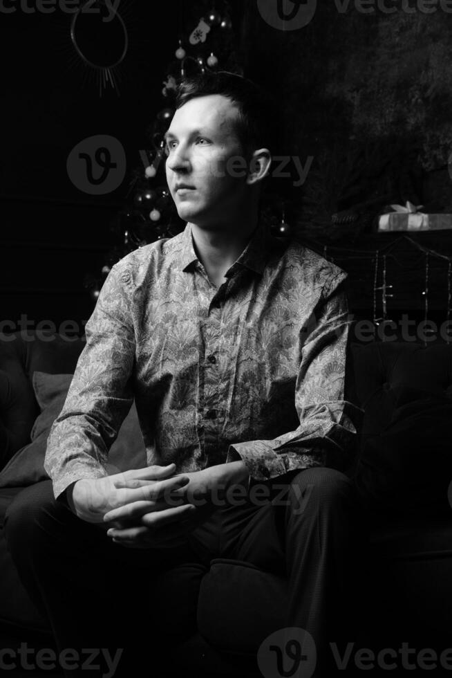 A Thoughtful and Reflective Portrait of a Man Sitting Comfortably in Black and White photo