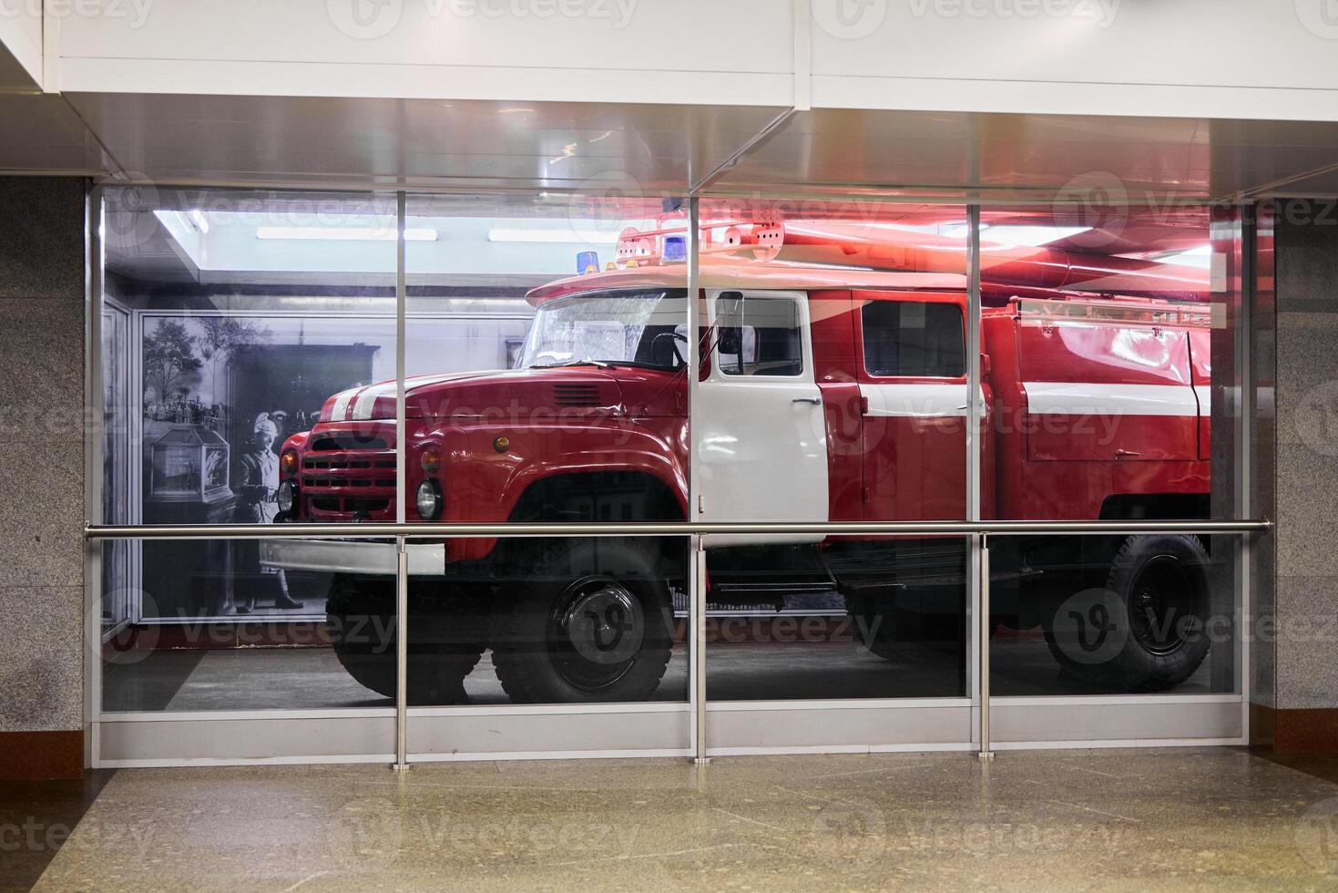 A Stunning Display Showcasing a Vintage Fire Truck Set Within a Modern Urban Environment photo