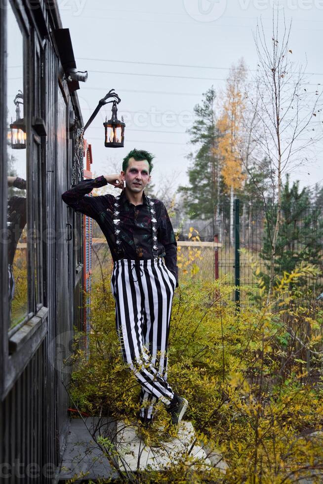 A Mysterious Clown in Striped Pants wanders through a beautiful Autumn Landscape photo