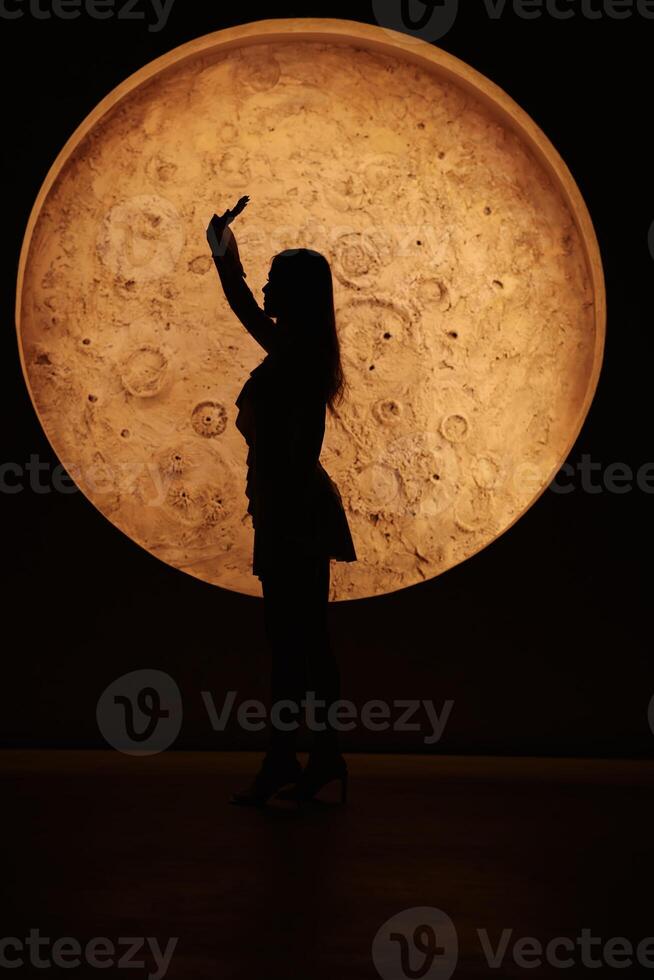 Silhouette Dance Against a Big, Bright Moon in the Night Sky, Creating an Ethereal Scene photo