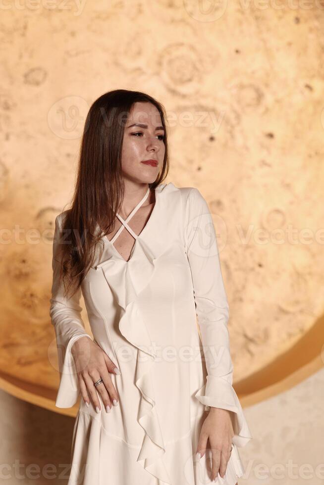 An Elegant Model Posing Gracefully in a Gorgeous White Dress Against a Beautiful Textured Background photo