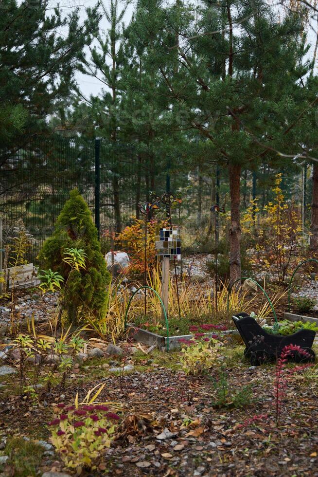 A Colorful Autumn Garden Featuring Evergreen Trees, Beautiful Decorative Elements, and More photo