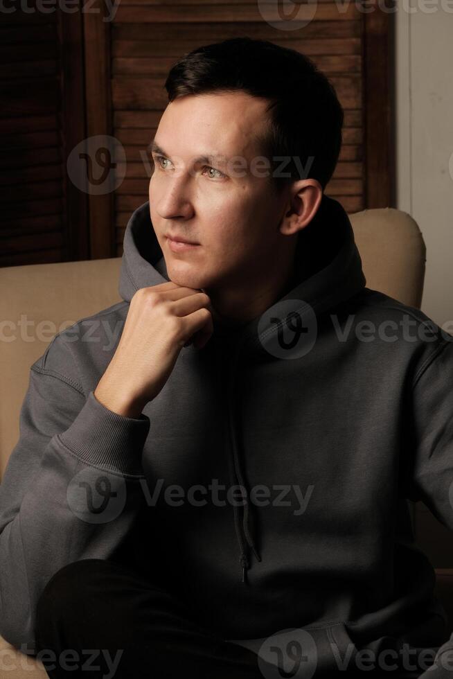 A Thoughtful Young Man Dressed in Comfortable Casual Attire, Evoking a Relaxed Atmosphere photo