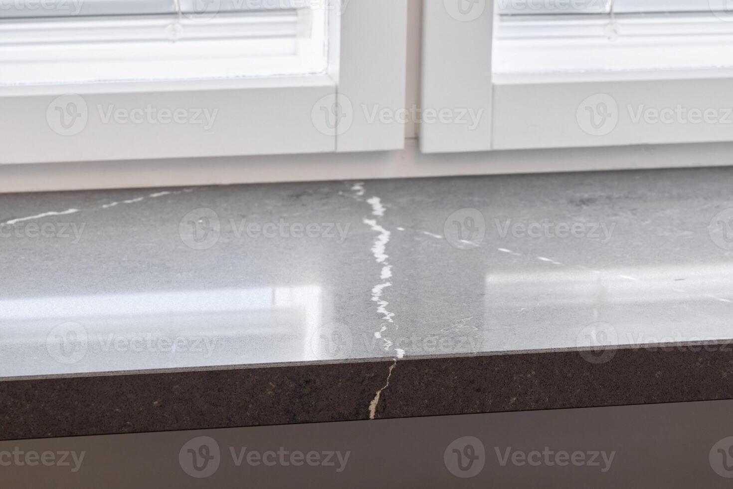 This Elegant Gray Countertop Features Striking Veins and Receives Ample Natural Light photo