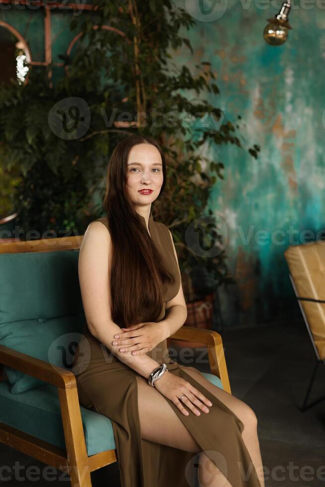 An Elegant Woman is Posing Gracefully in a Stylish Interior Filled with Beautiful Greenery photo