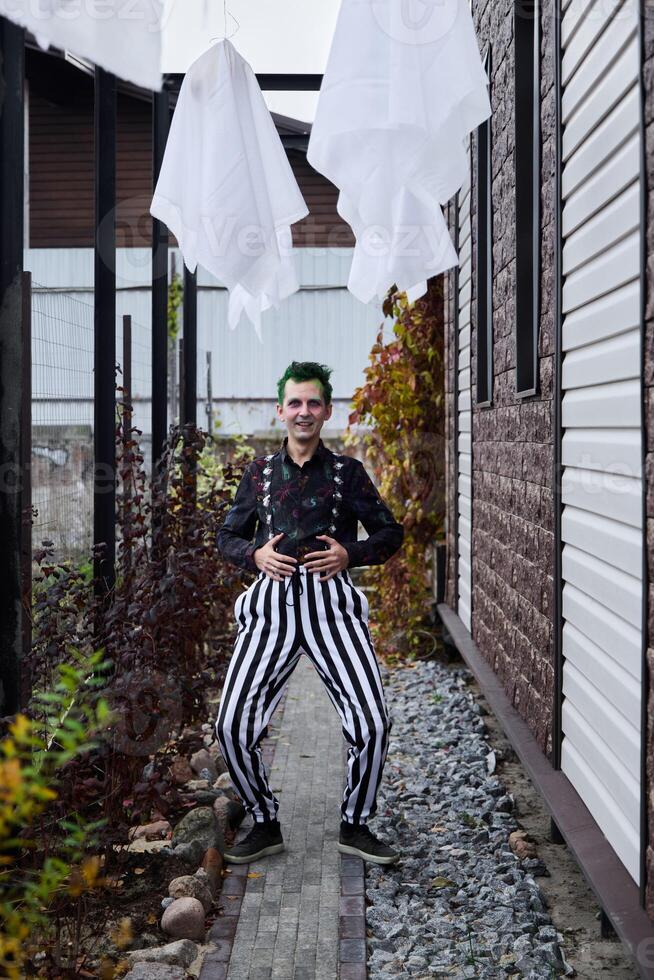 A Playful Clown Wearing Colorful and Striped Pants Cheerfully Poses by the Charming Pathway photo