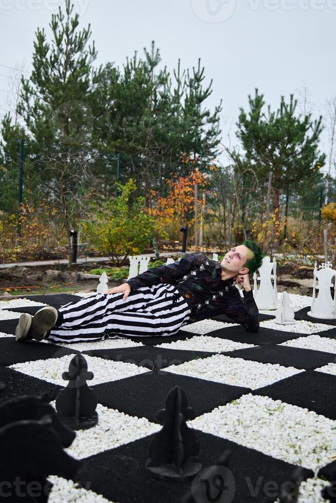 A surreal chessboard scene featuring a person in a strikingly striped outfit and vibrant colors photo