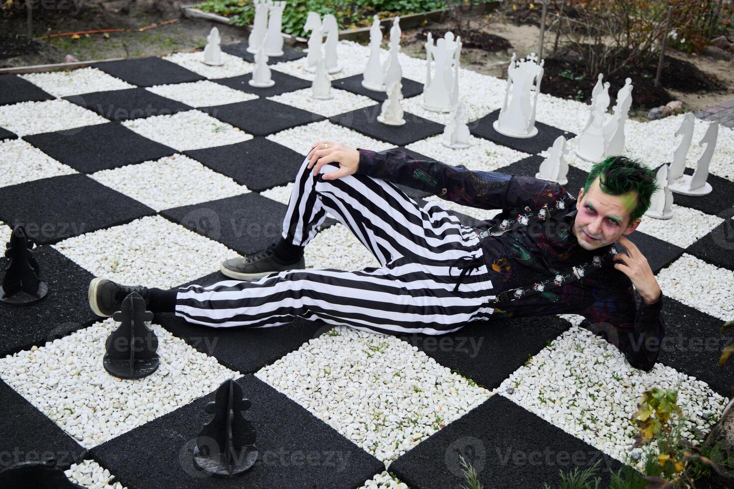An Eccentric and Vibrant Chessboard Scene Featuring a Unique Character and Giant Game Pieces photo