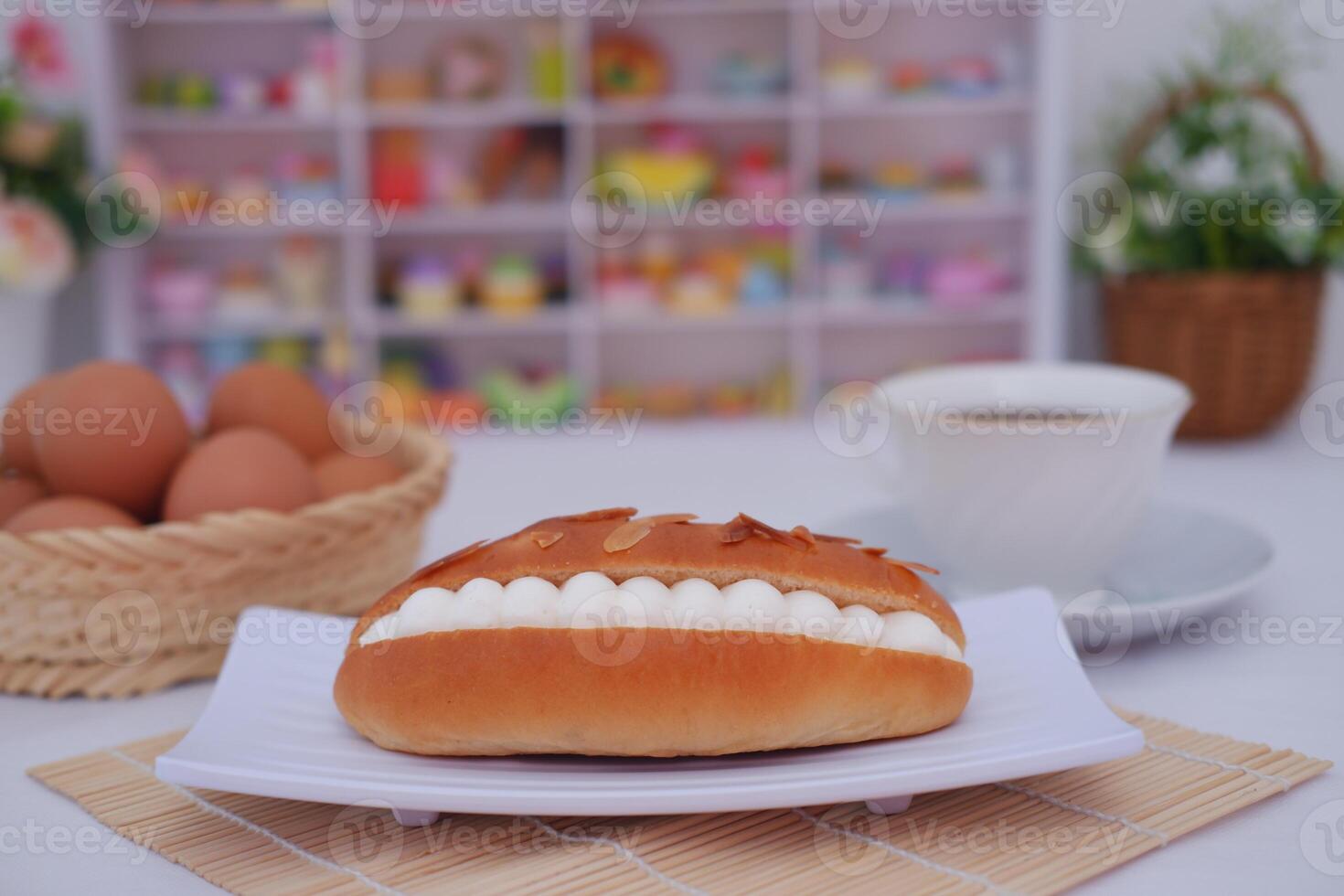 Delicious pastry with cream filling and almond flakes on a white plate. photo