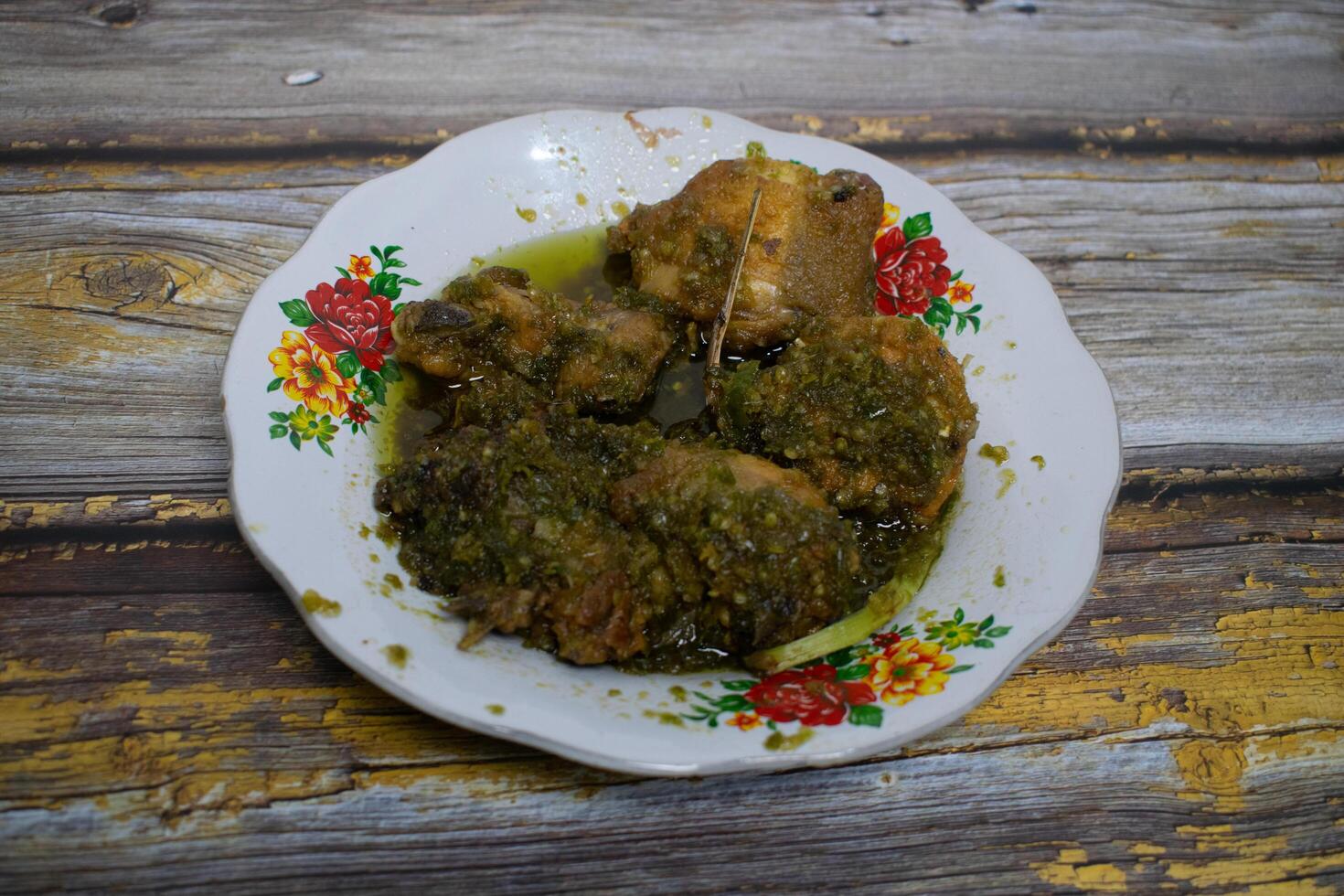 Traditional green chili fried chicken served on floral patterned porcelain plates and rustic wooden table photo
