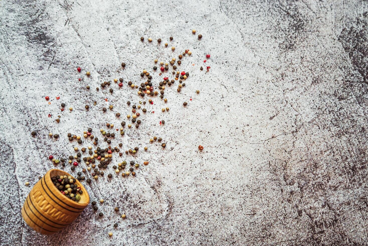 a mixture of peppers, spices sprinkled on a gray table photo