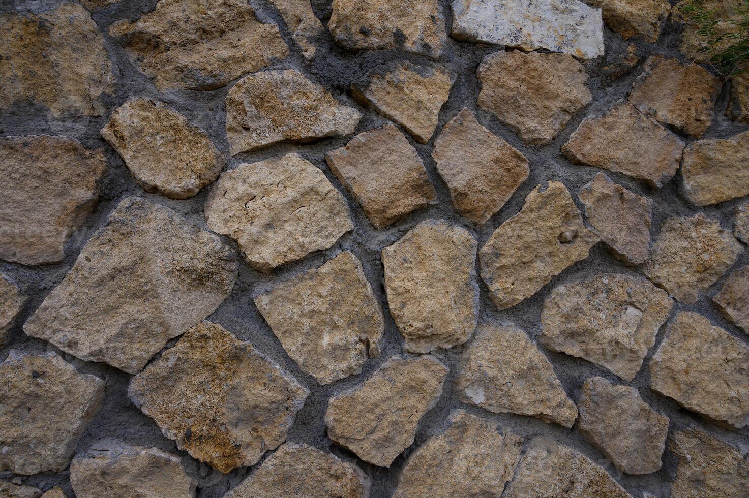 Close-up of a natural stone wall in Cyprus, showing rustic texture and warm colors, perfect as a background or design element. photo