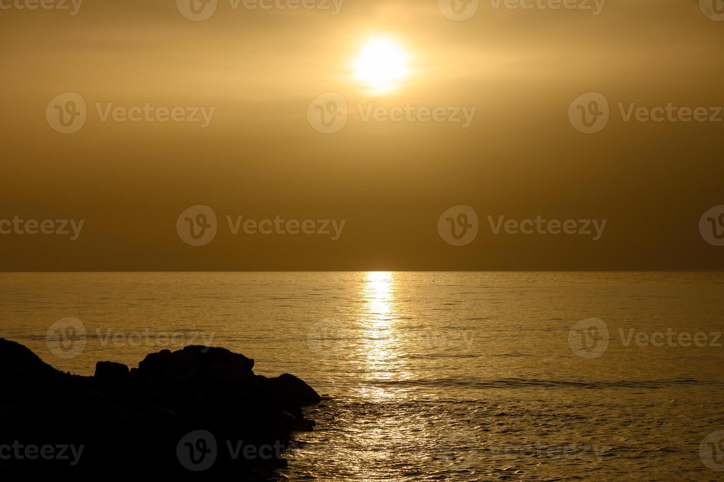 Golden sunset over the calm Mediterranean Sea on the coast of Cyprus. photo