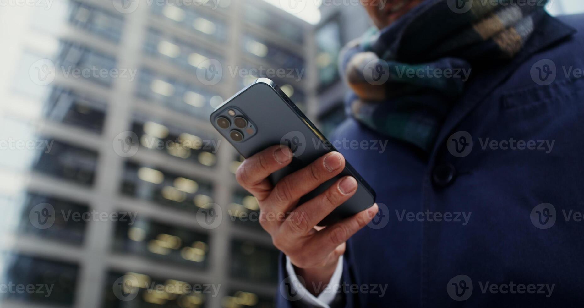 Modern smartphone in the hands of a businessman, close-up, unrecognizable person, no face. filming in the open air in the office center of the city. in 4k, red komodo photo