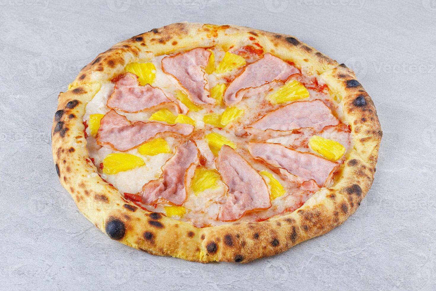 Hawaiian Pizza with Ham and Pineapple on Stone Surface photo