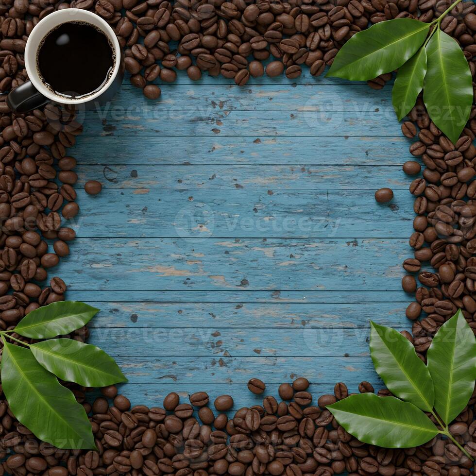 A cup of black coffee is placed within a frame formed by roasted coffee beans and green leaves on a textured blue wooden background photo