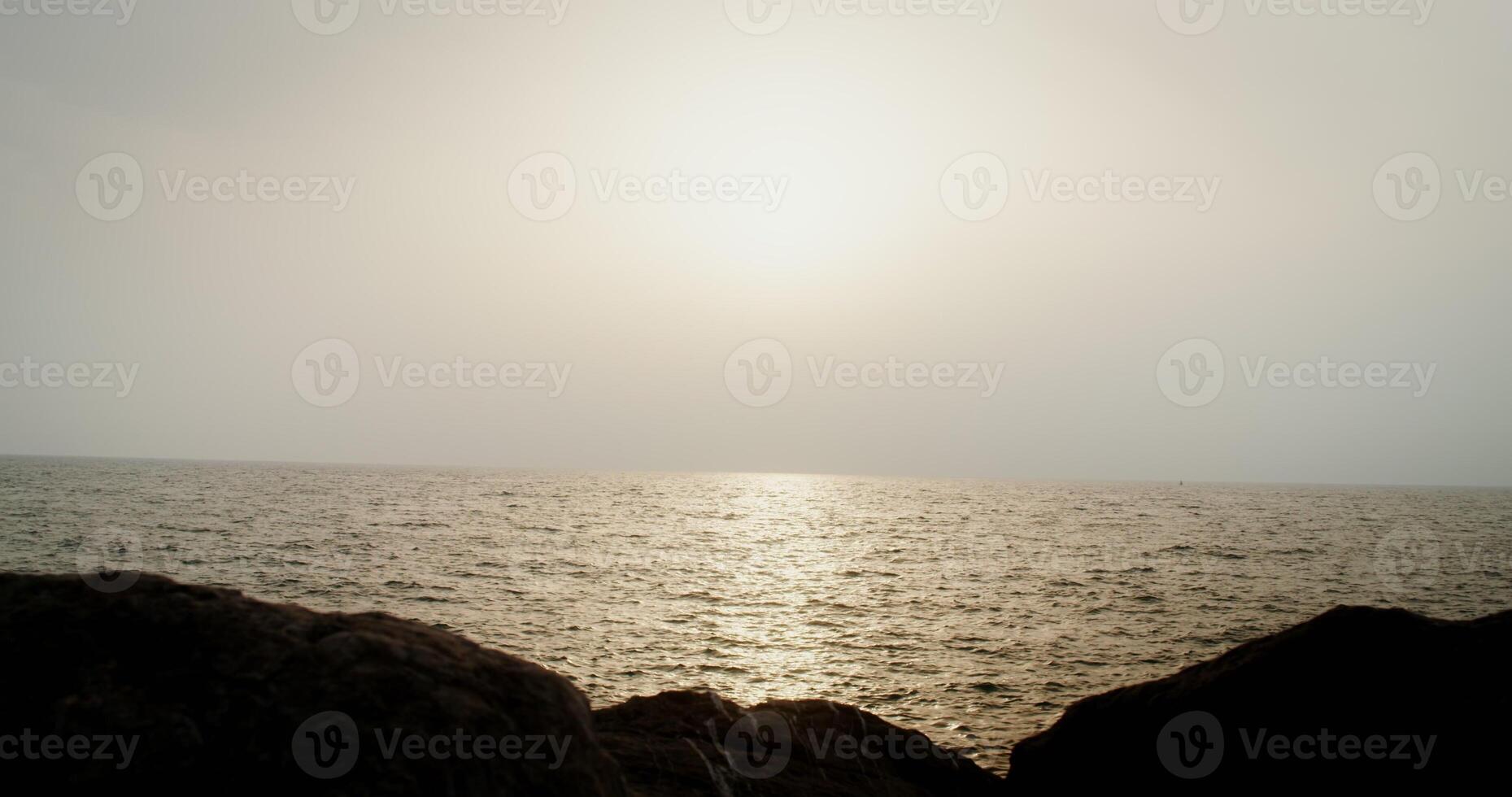 View of the sea with the reflections of the setting sun on the sea ripples. filming from the rocky shore. 4k , red komodo photo