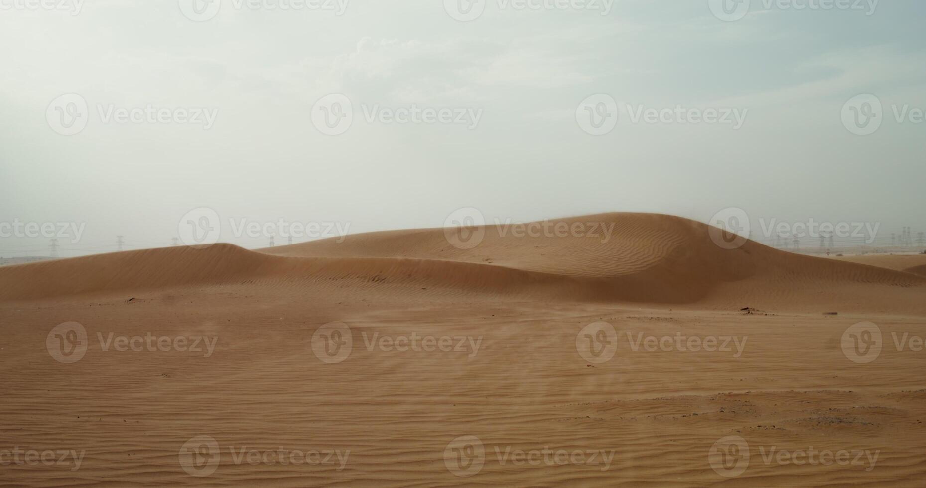 Wind inflates the sands of the desert, forming a beautiful sandy pattern. Desert sand dunes. Power lines in the background. 4k , red komodo photo