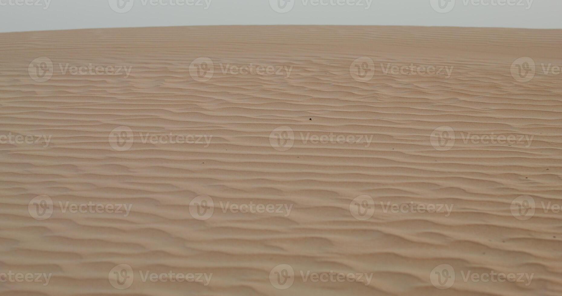 Patterns on sand in desert. The moves from sand waves to a general view of the desert with a sandy haze photo