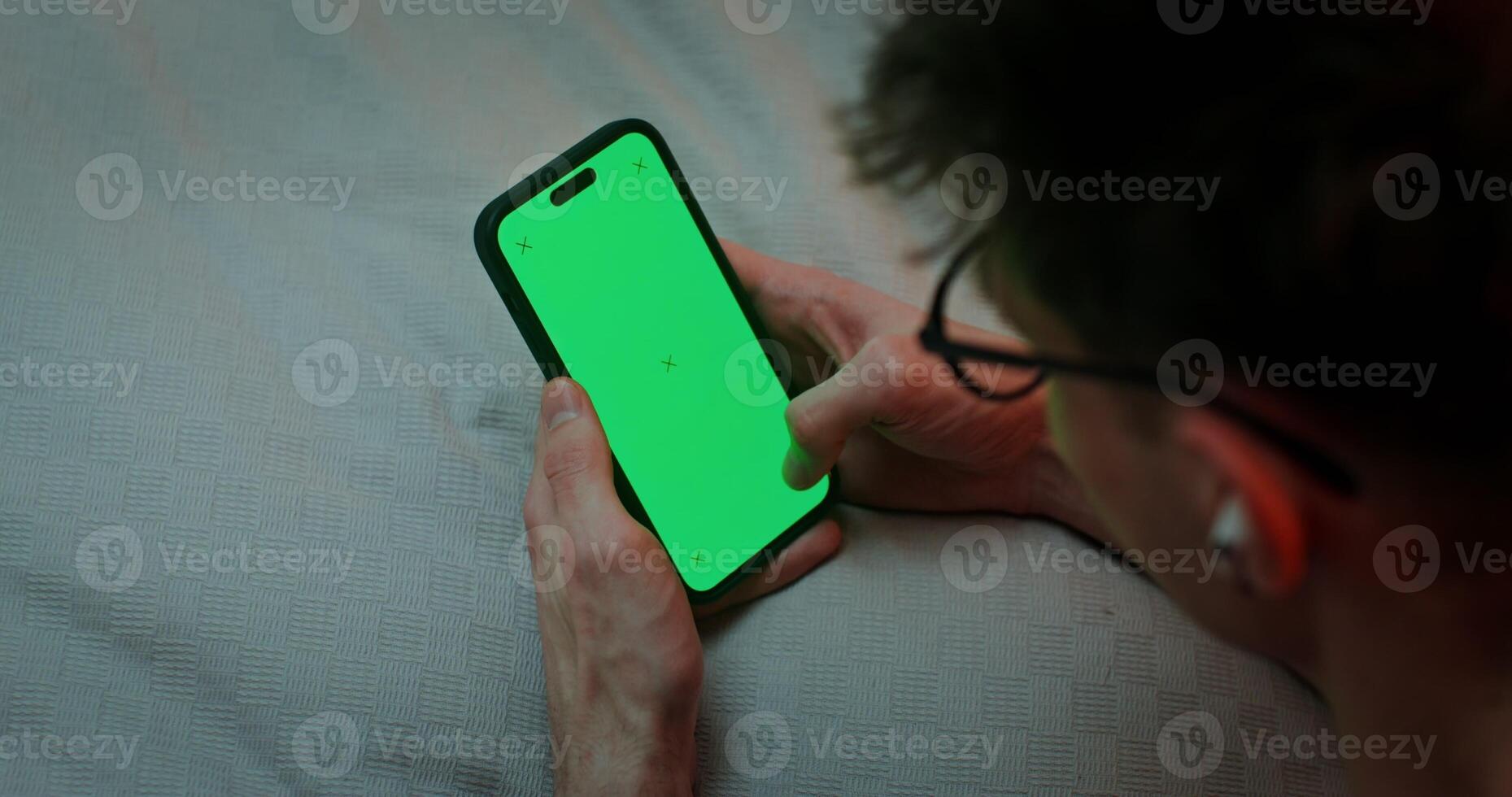 Close-up of mobile phone with a green screen in the hands of a young man. Chromakey, mockup, copy space photo