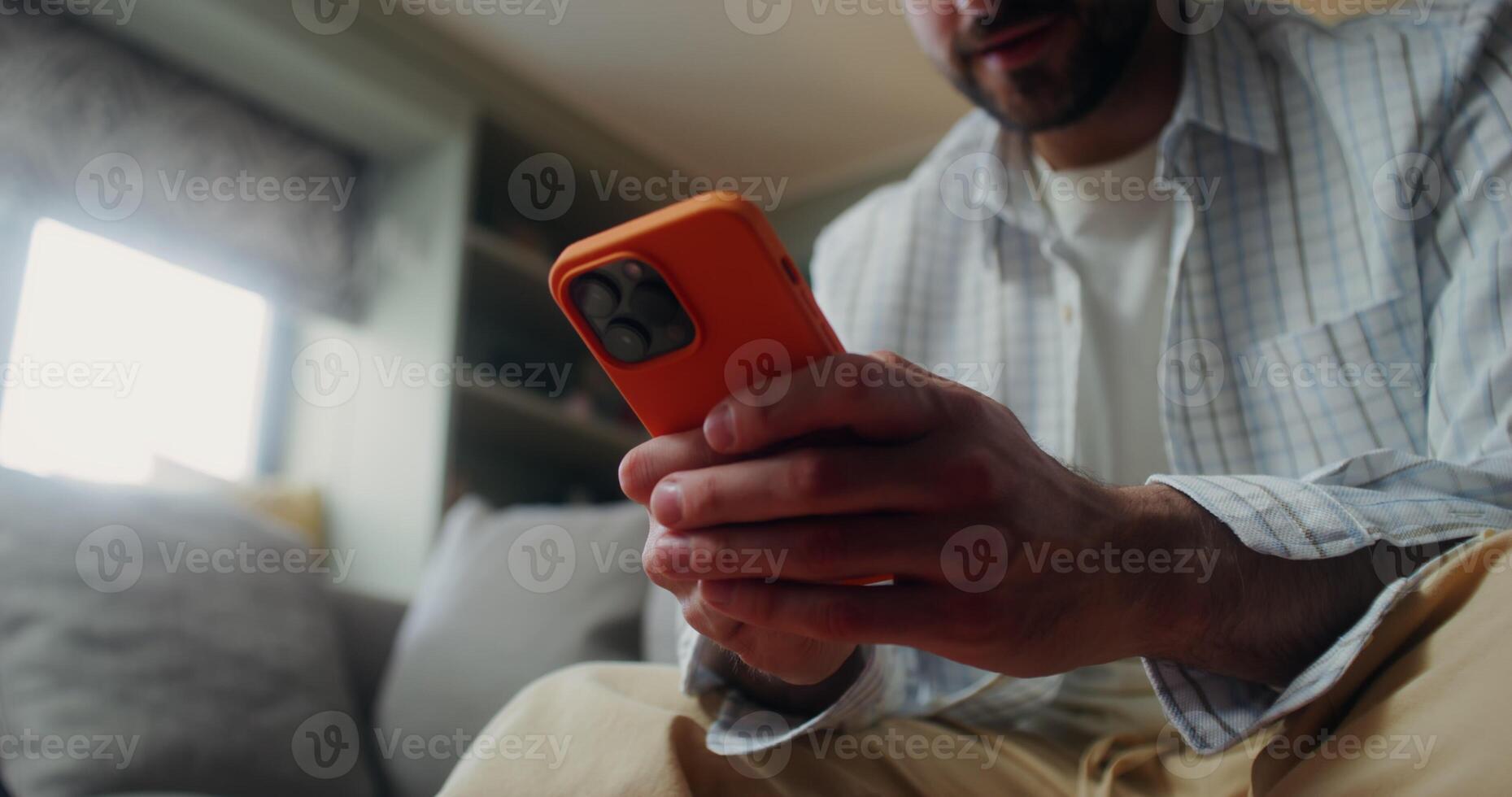 A man in casual clothes uses a mobile phone photo