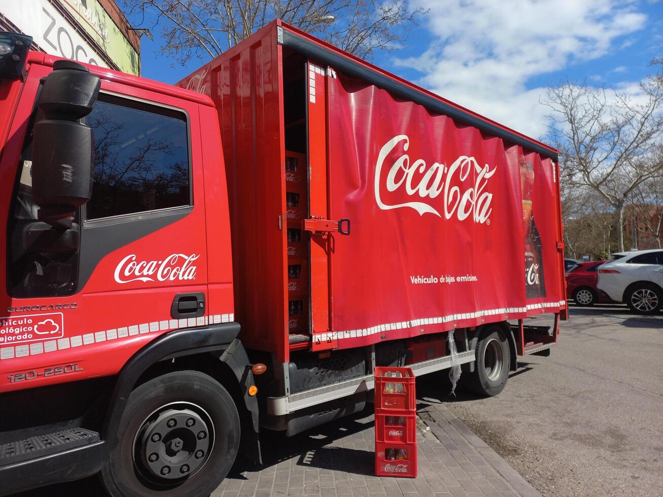 MADRID, SPAIN - MAY, 15, 2025. Coca cola delivery truck unloading in urban setting under blue sky photo