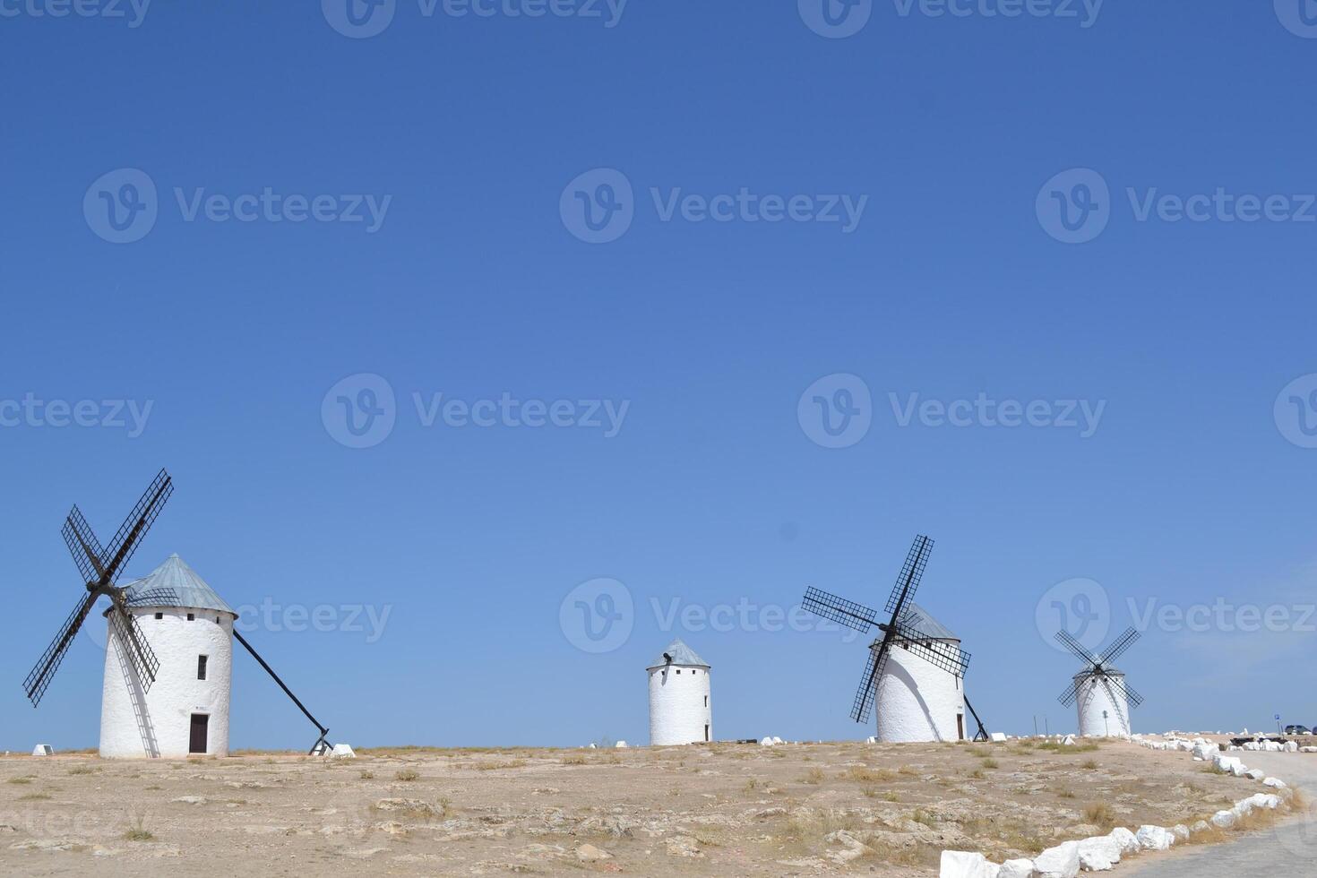 Traditional spanish windmills under clear blue sky in la mancha region. Campo de Criptana. La Mancha. Spain photo