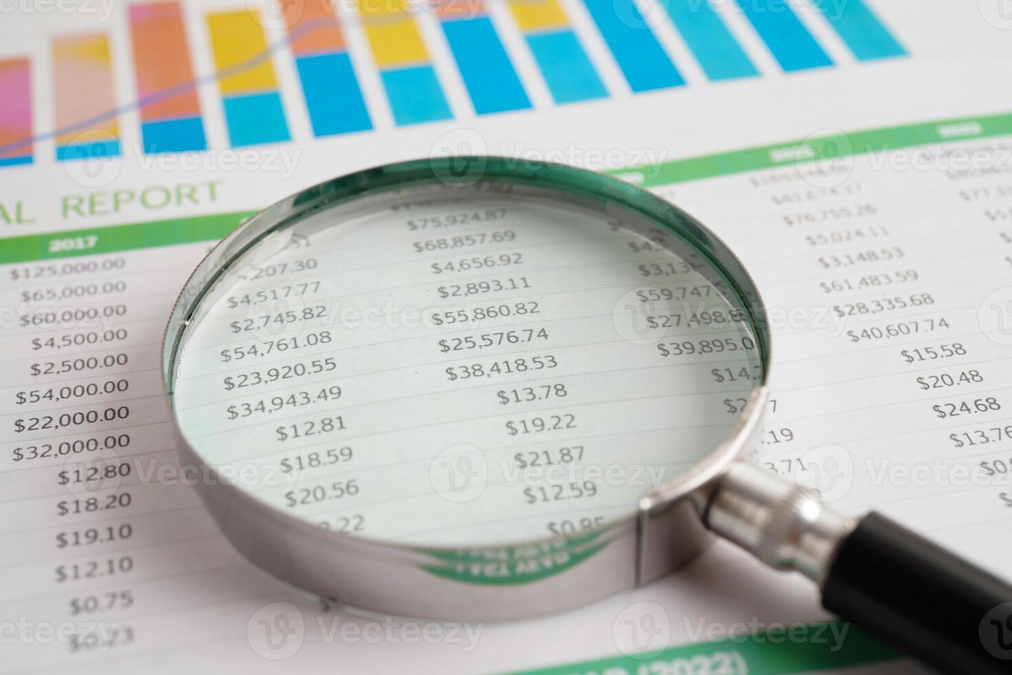 Magnifying glass on spreadsheet chart paper. photo