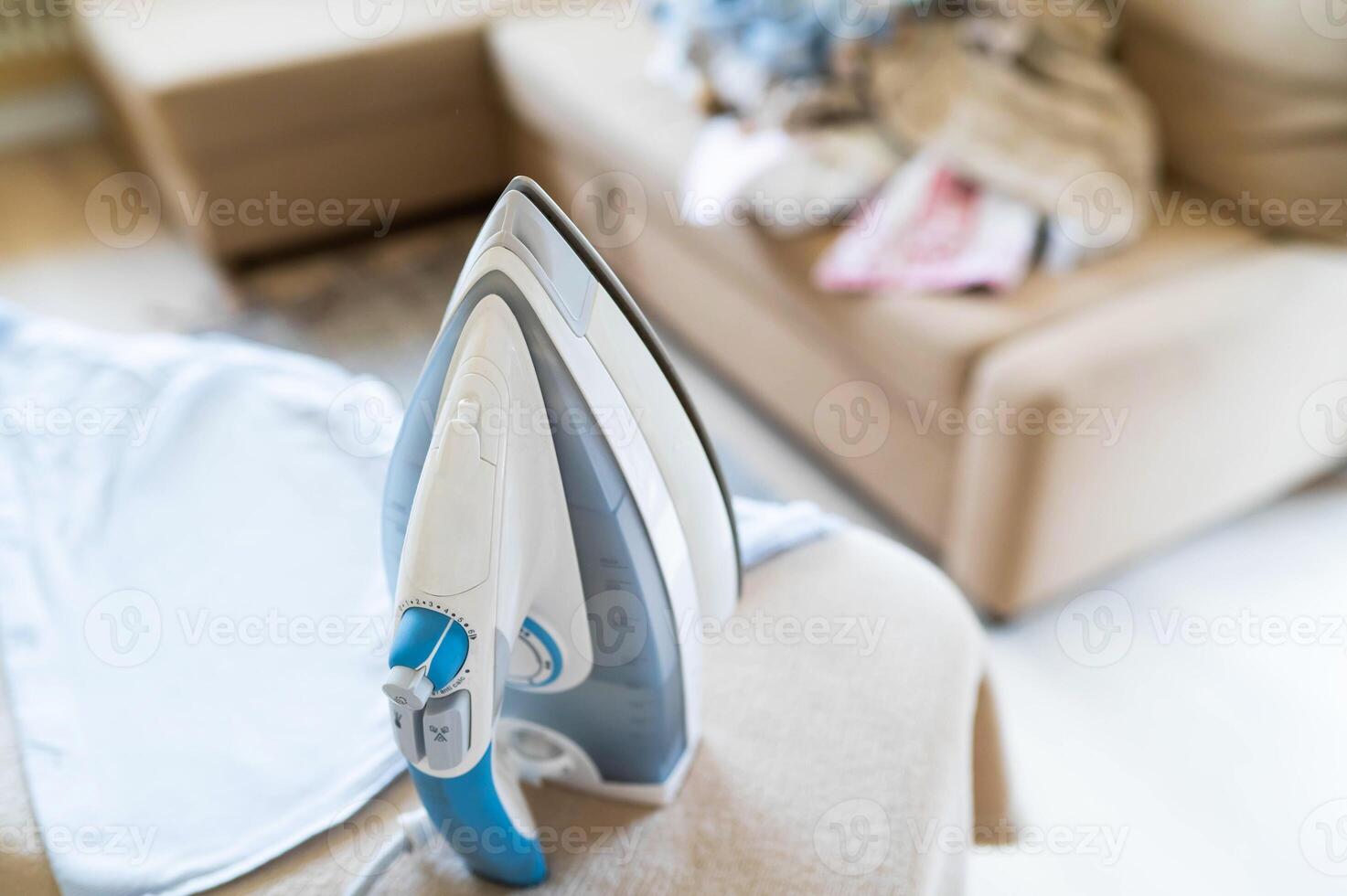 A blue and white iron sitting on top of a couch photo