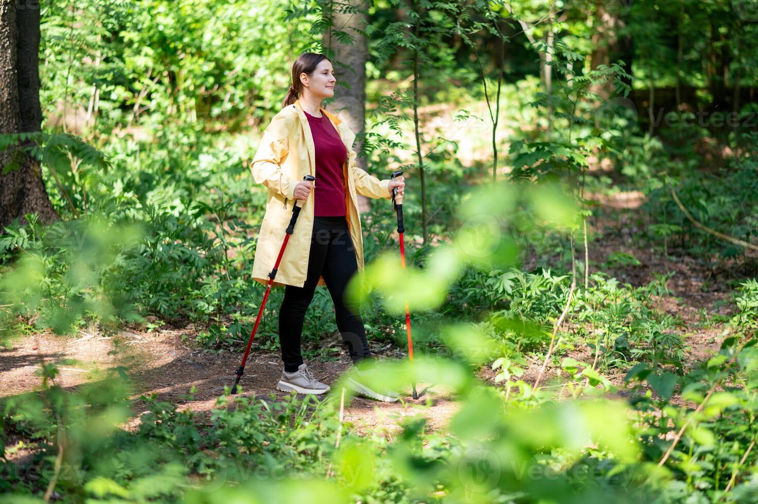 A woman with walking poles in the woods photo
