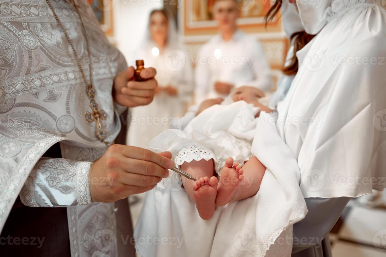 A priest holding a baby in a white robe photo