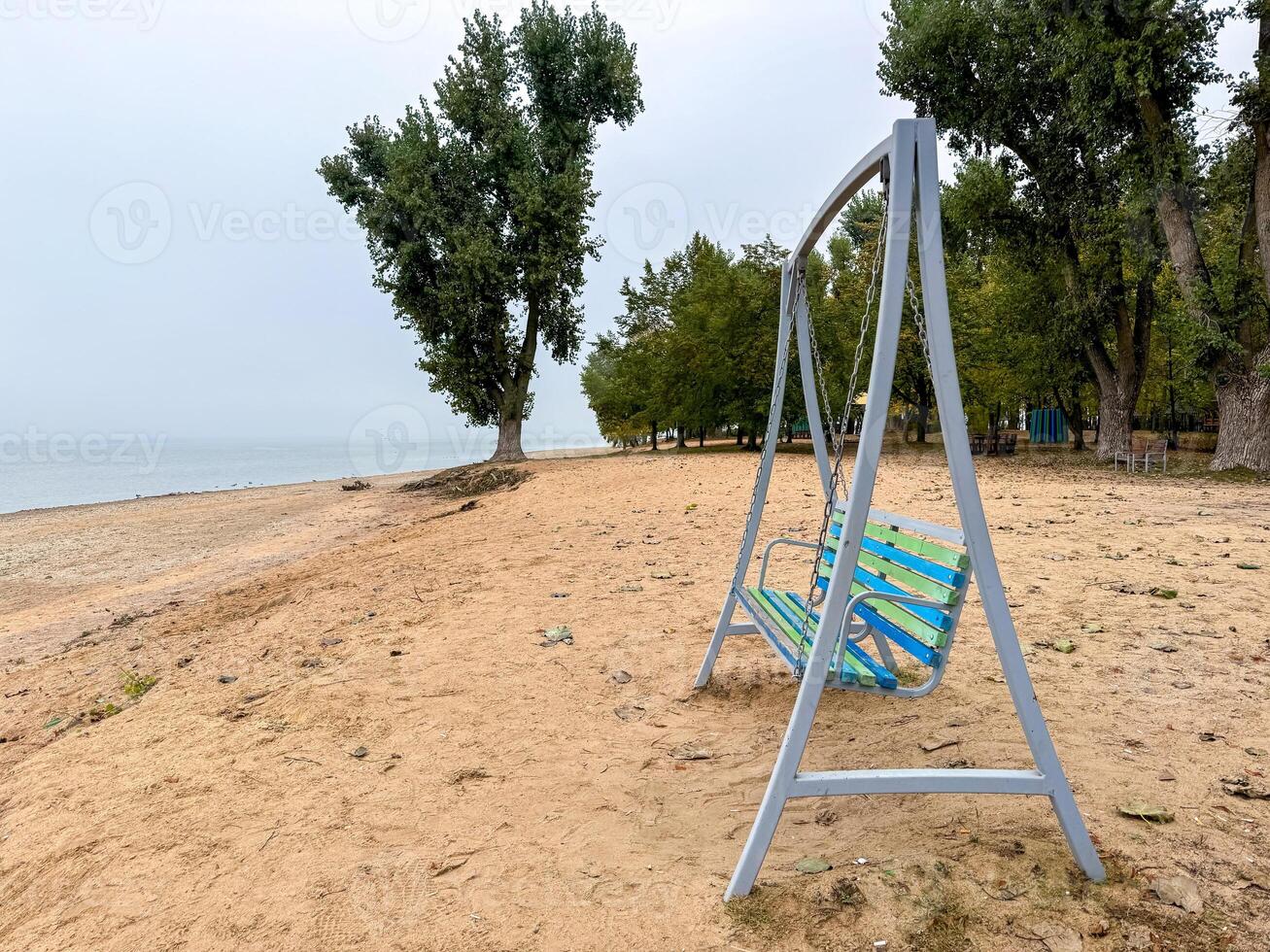 Empty swing on the beach photo