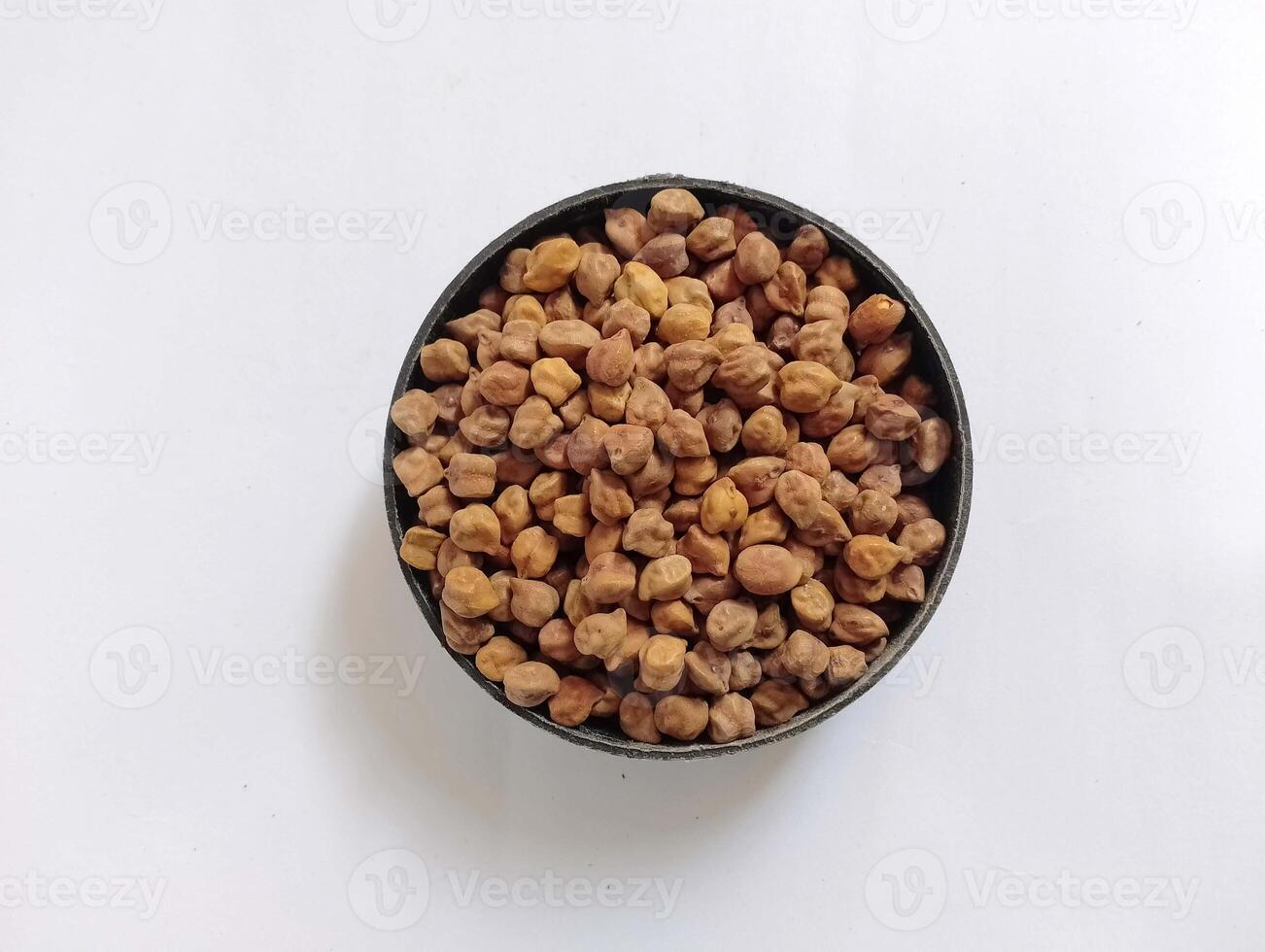 Dried black chickpeas in rustic bowl, clearly isolated. photo