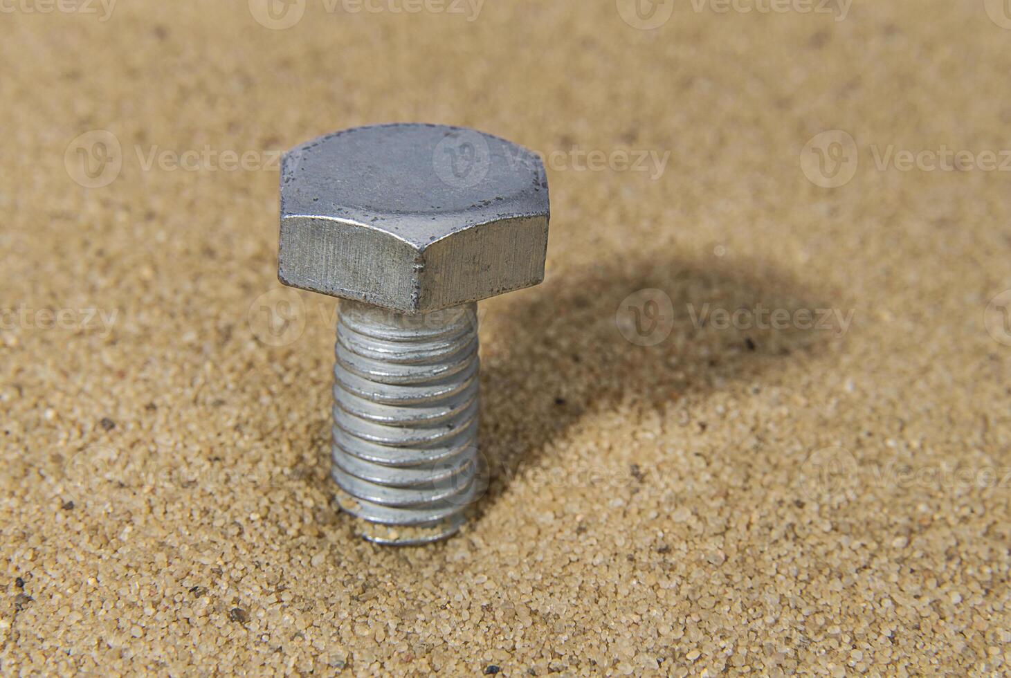 Steel screw in the sand photo