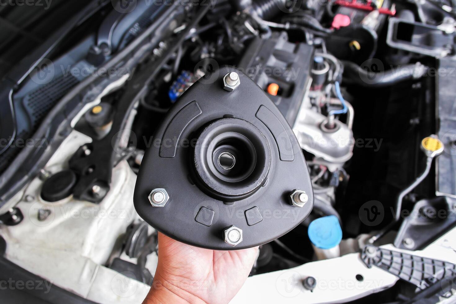 Shock Absorber Strut Mount, Top strut mount of suspension shock absorber strut in mechanic hand. photo