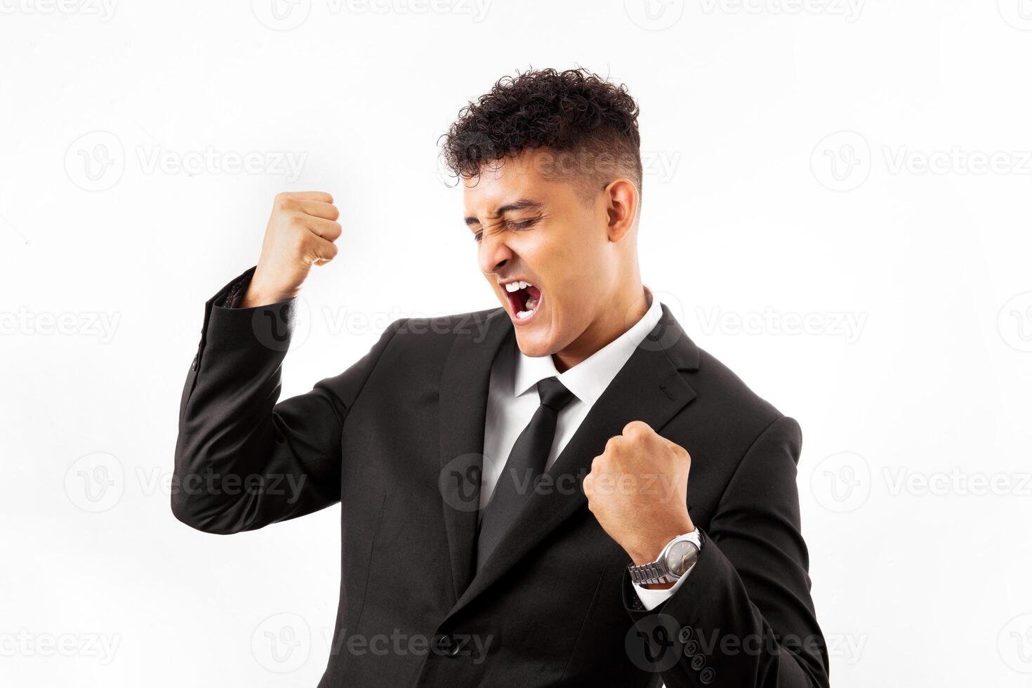 Portrait of a handsome man wearing business suite over white background very happy and excited doing winner gesture with arms raised, smiling and screaming for success. Celebration photo