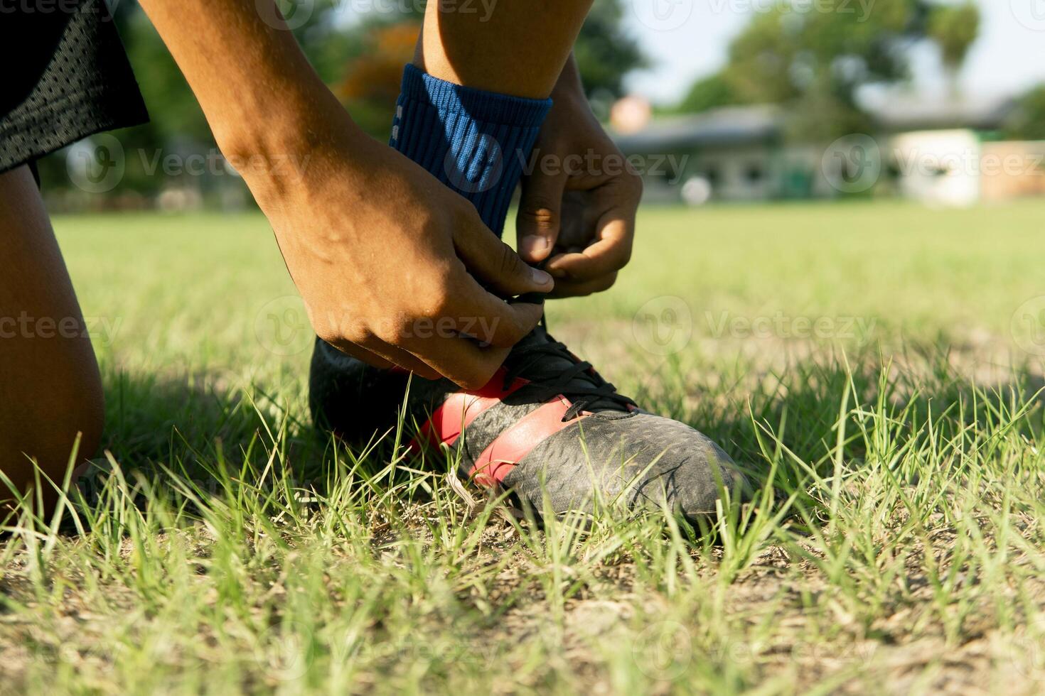 Latin american soccer player tying cleats on field, dedication and skill before match photo