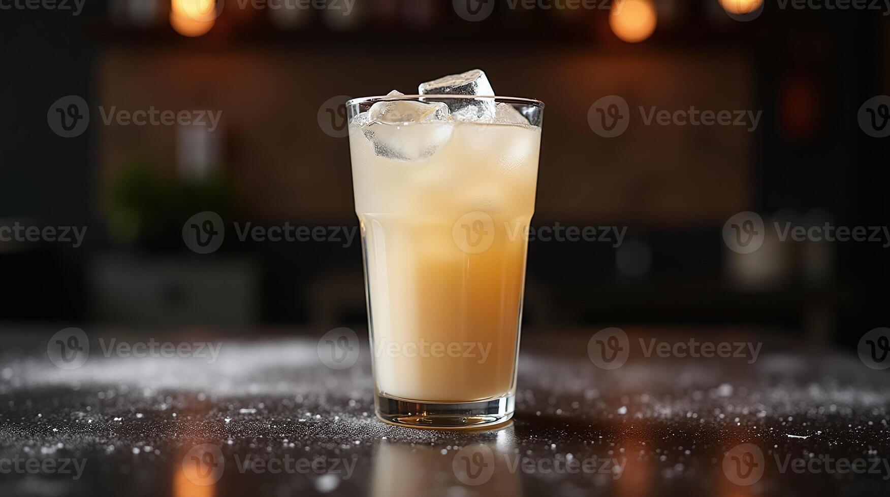A well-crafted cocktail garnished with ice cubes, set against a blurred bar backdrop. photo