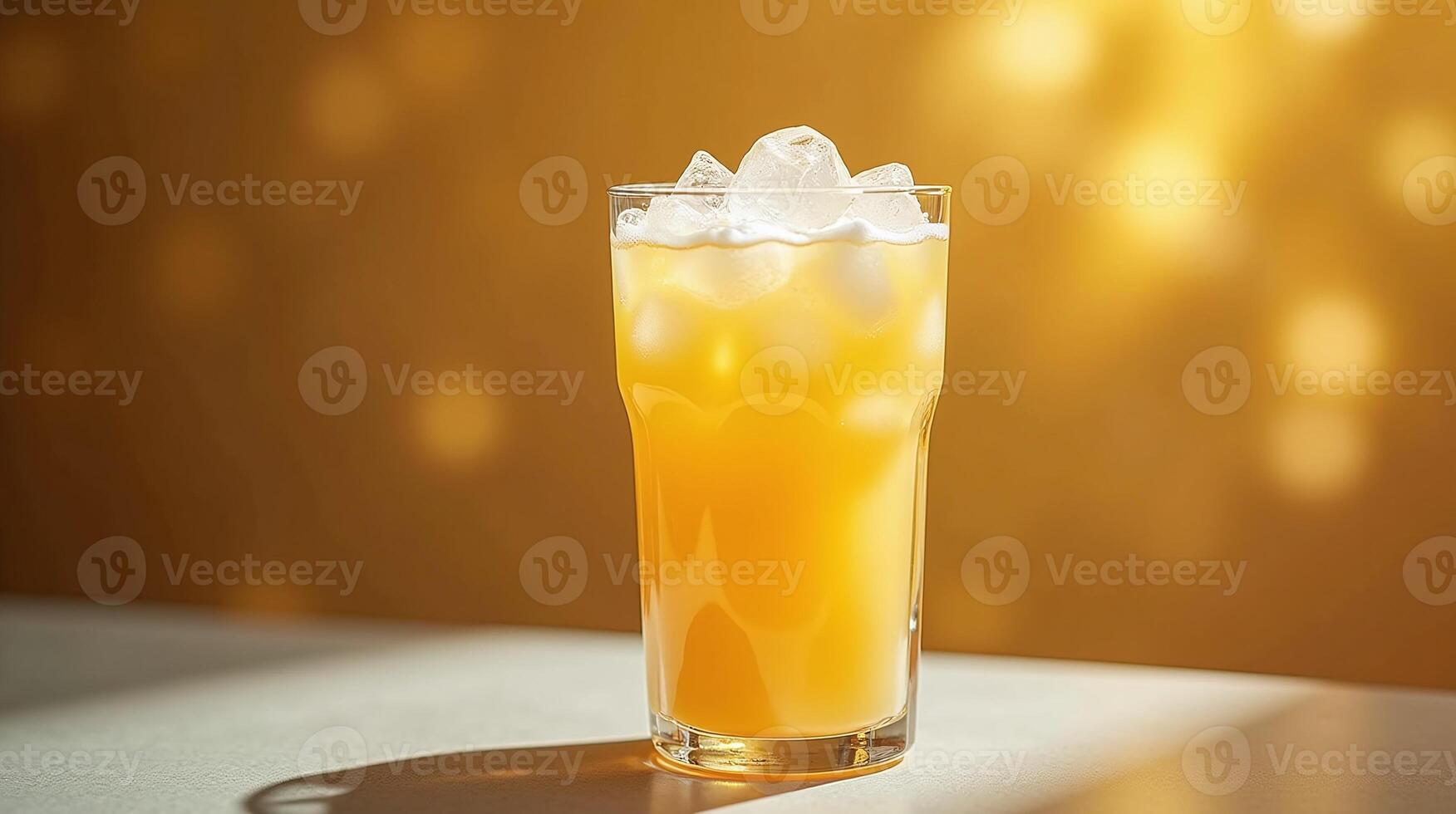 A vibrant, refreshing glass of citrus beverage with ice against a warm, bokeh background. photo