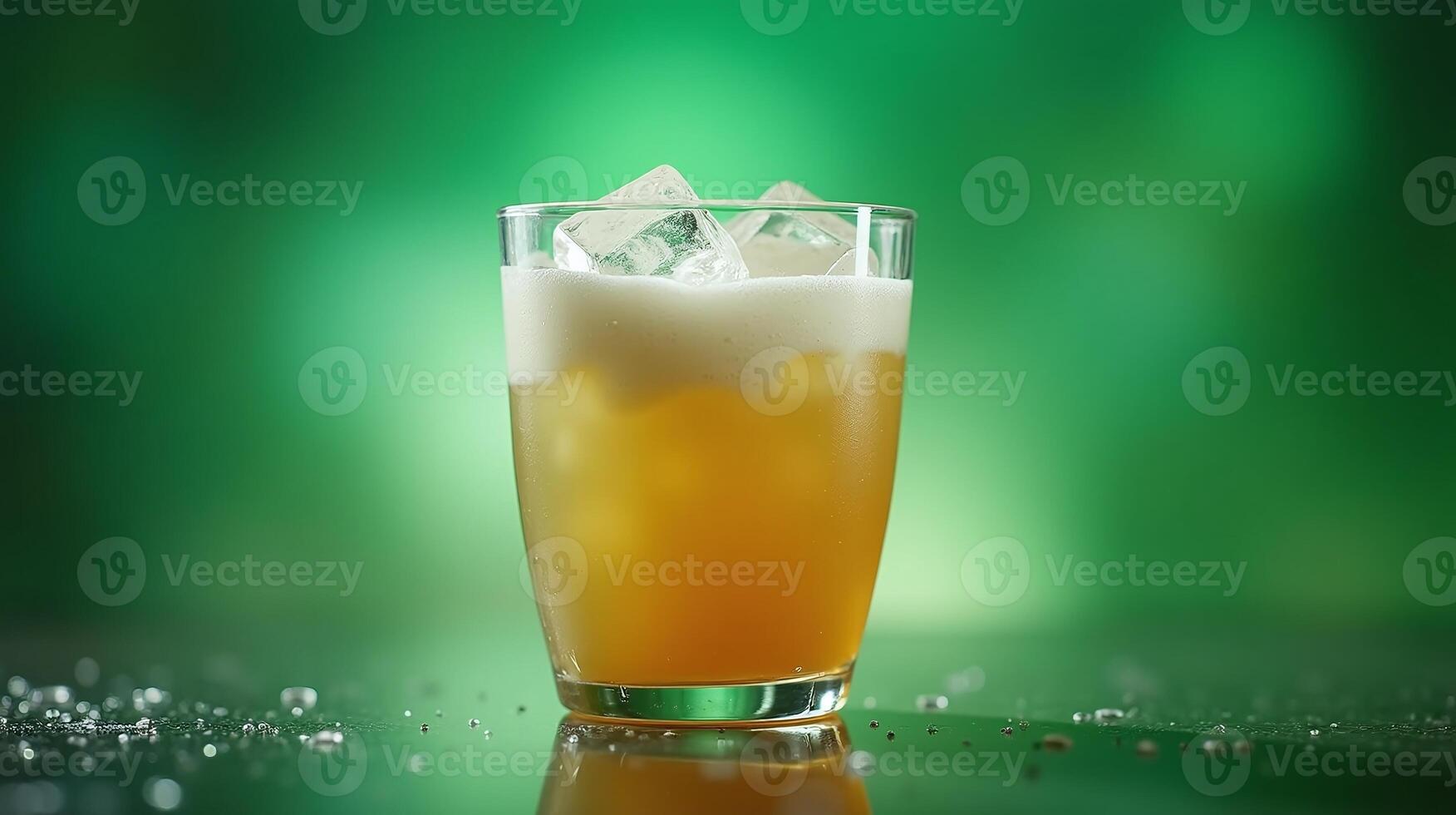 A frothy beer glass with ice, set against a green background. photo