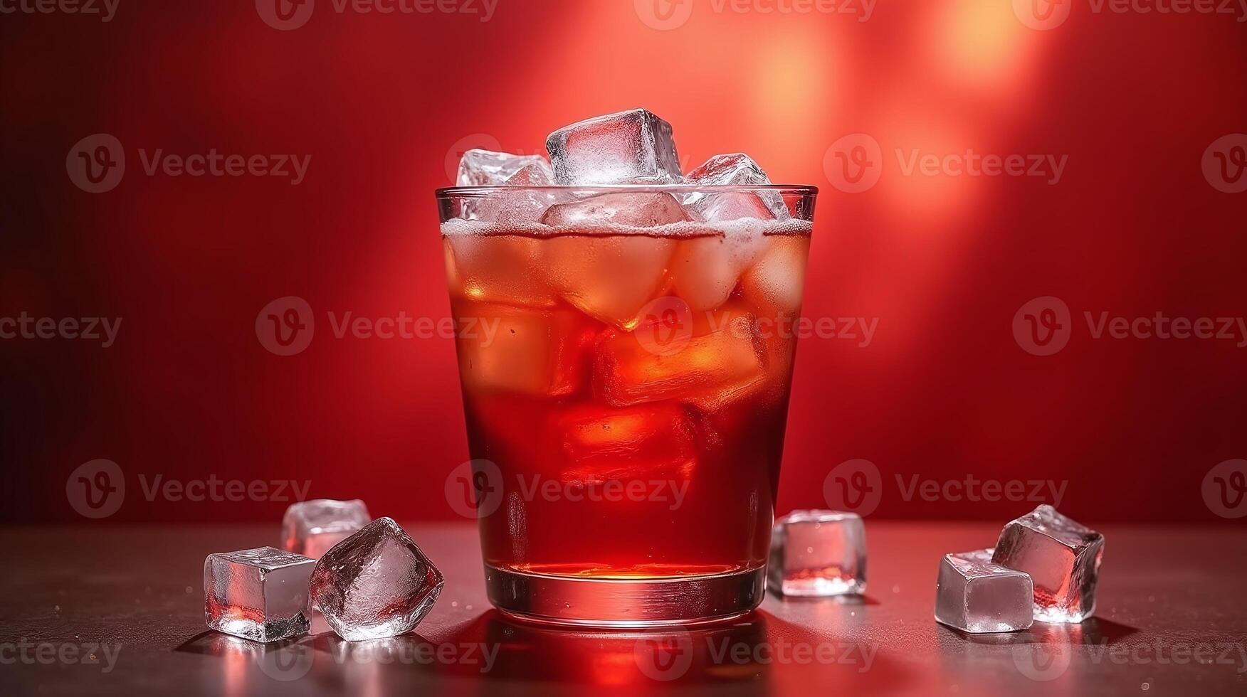 A glass container filled with a reddish liquid, surrounded by ice cubes against a red background. photo
