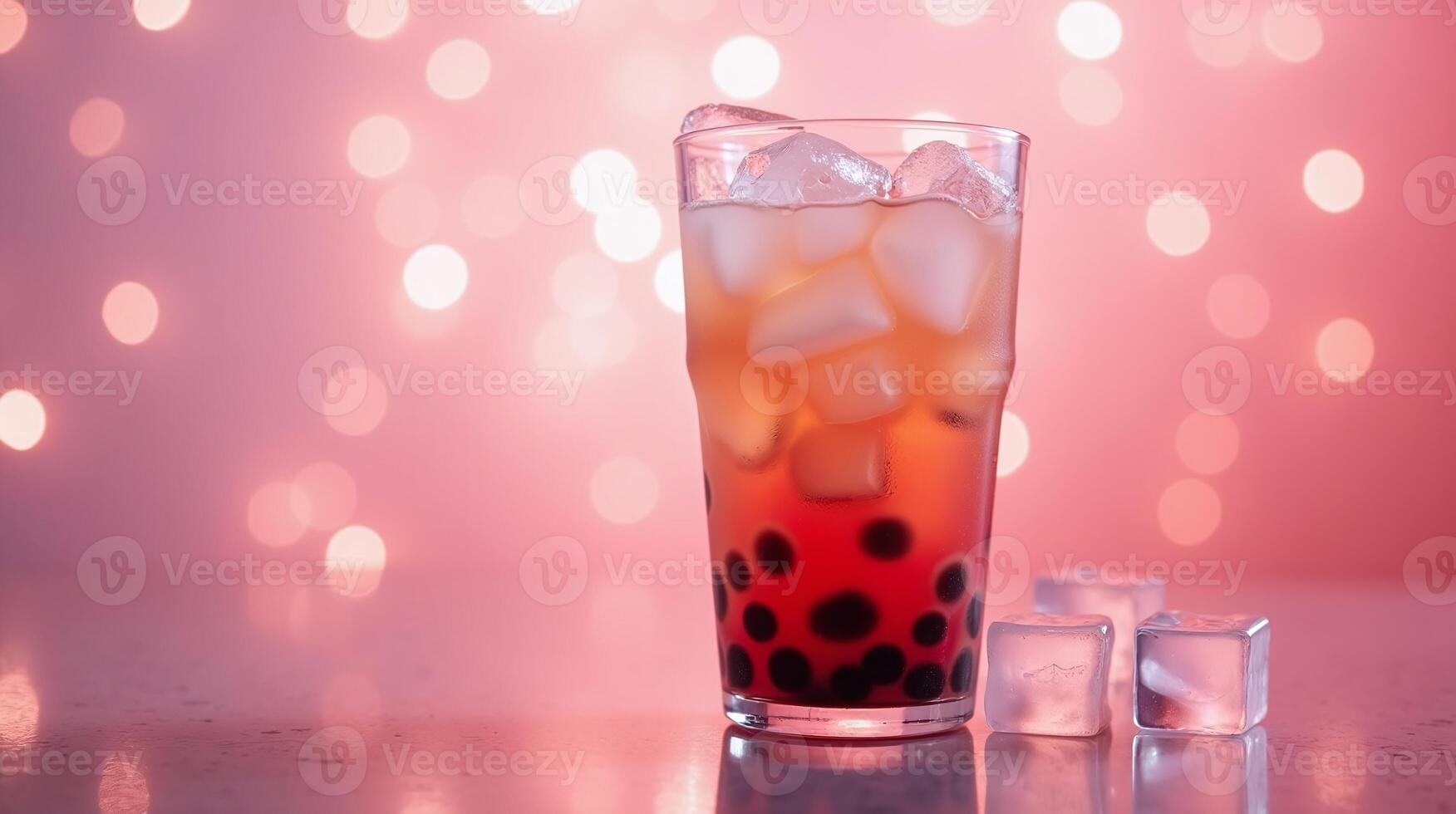 Cocktail glass filled with ice cubes, red liquid, and dark bubbles. photo