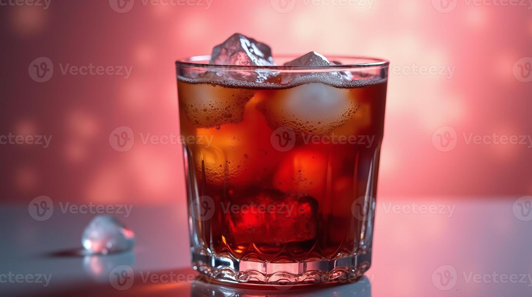 A glass of dark liquid with ice cubes against a red background. photo