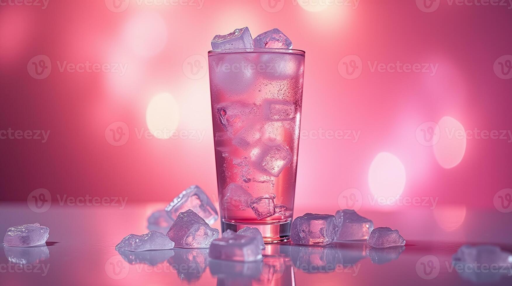 A glass filled with a refreshing beverage and ice cubes against a vibrant pink background. photo