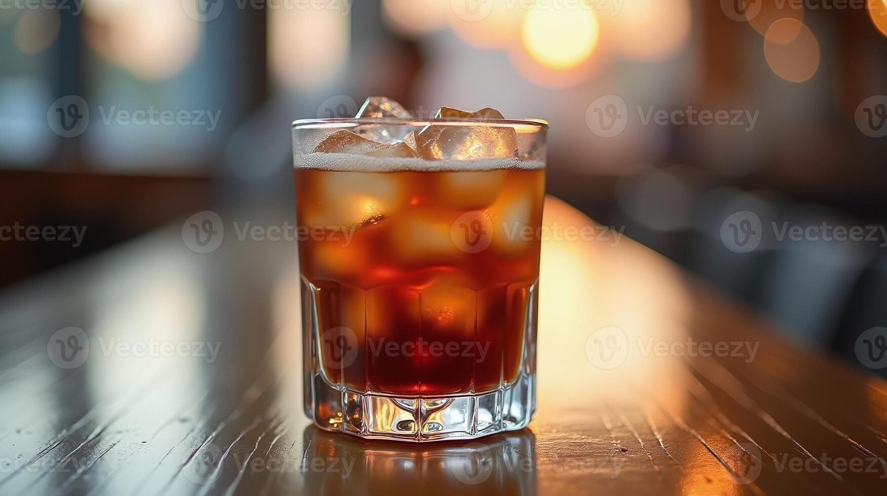 Delightful amber beverage in a glass with ice, against a softly blurred backdrop. photo