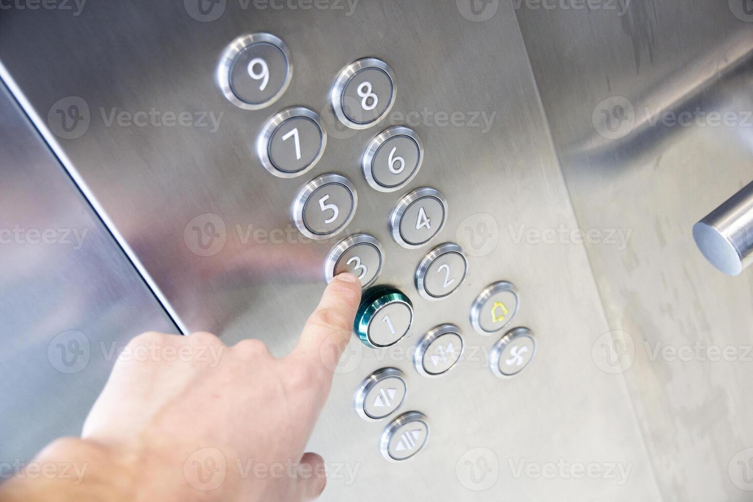 A person pressing a button on an elevator photo