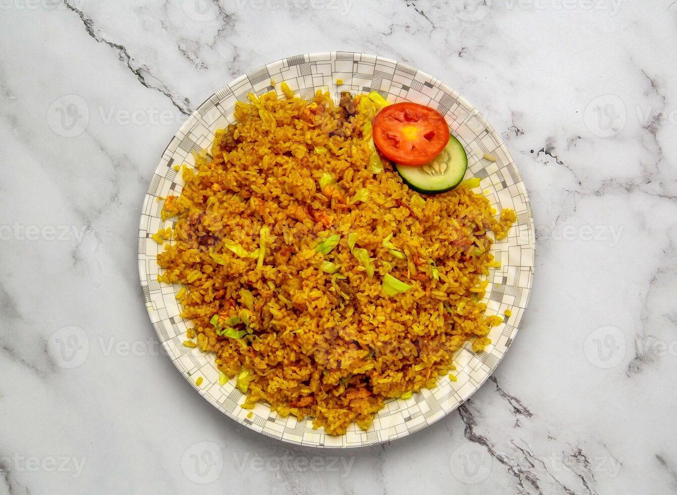 Beef Fried Rice with Vegetables Served on Plate with Sliced Tomato and Cucumber photo